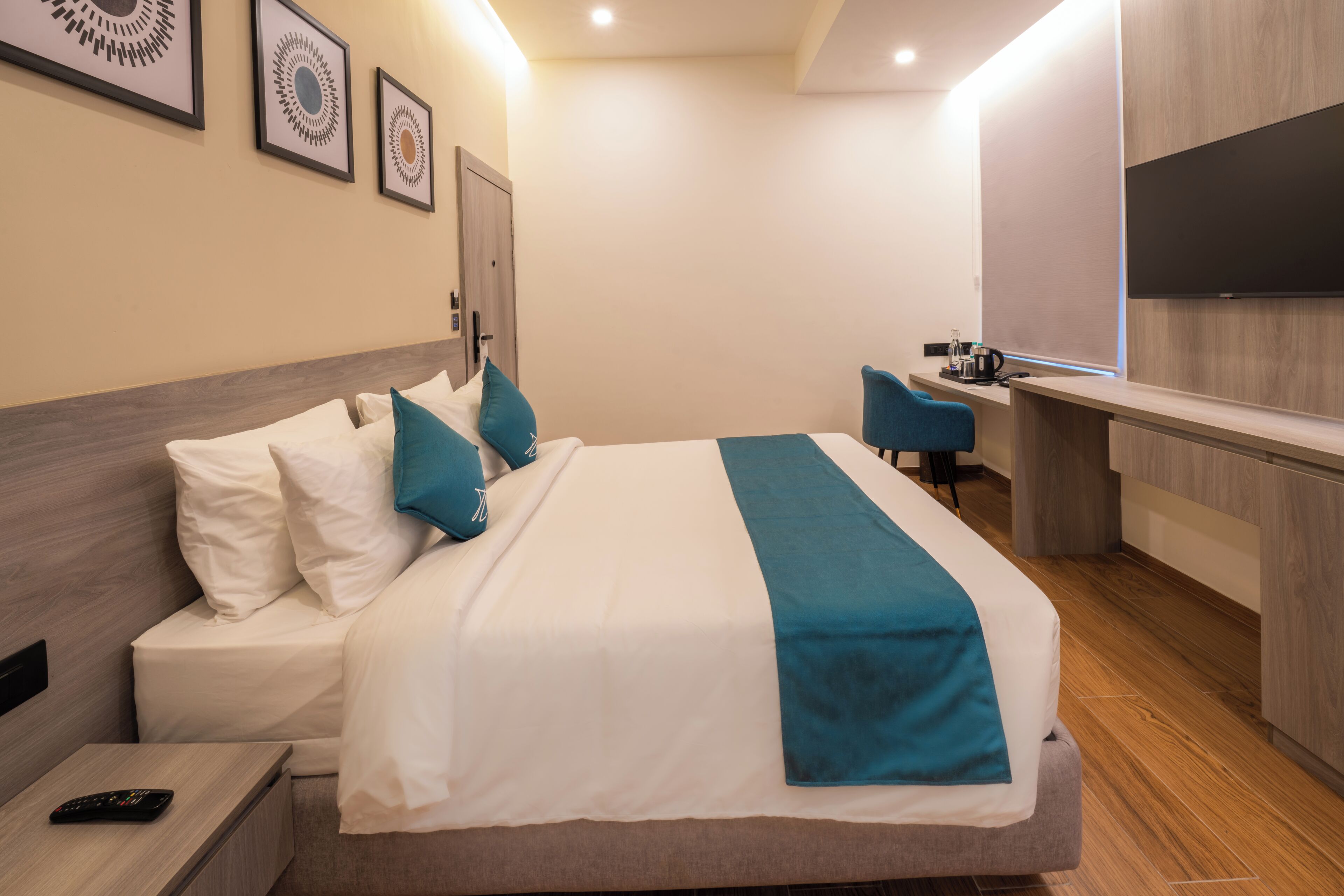 Una habitación de hotel moderna con una cama grande, un escritorio y un televisor.