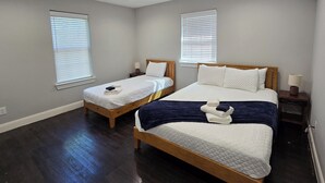 Ein Hotelzimmer mit zwei Betten, Holzboden und Deckenleuchten.