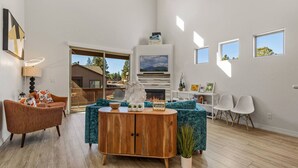 Un salón amplio con chimenea, una mesa de centro de madera y un sofá.