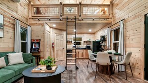 A cozy cabin interior with a living area, dining space, and kitchen. - Lux Sauna, Dome, Stargazing Net, Putting Green (Sevierville)