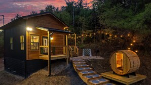 A cabin with a wooden exterior, a porch, and a barrel sauna. - Lux Sauna, Dome, Stargazing Net, Putting Green (Sevierville)