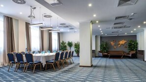 Una sala conferenze con un lungo tavolo, sedie e una mappa del mondo appesa al muro.