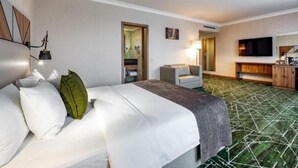 Una camera d'albergo con un letto, una scrivania, una sedia, una televisione e un tappeto decorato.