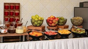 Un buffet con diversi tipi di frutta, ciotole e vasetti di condimenti.