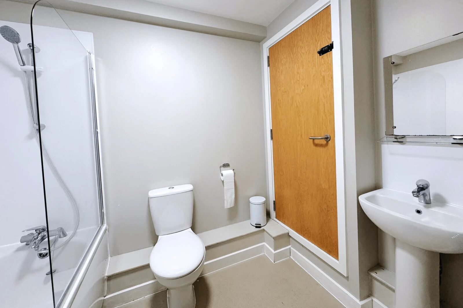 A bathroom with a shower, toilet, and sink.