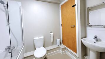 A bathroom with a shower, toilet, and sink.
