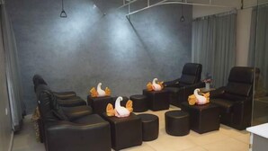 A modern relaxation area with black sofas and ottomans, some with decorative swan figures.