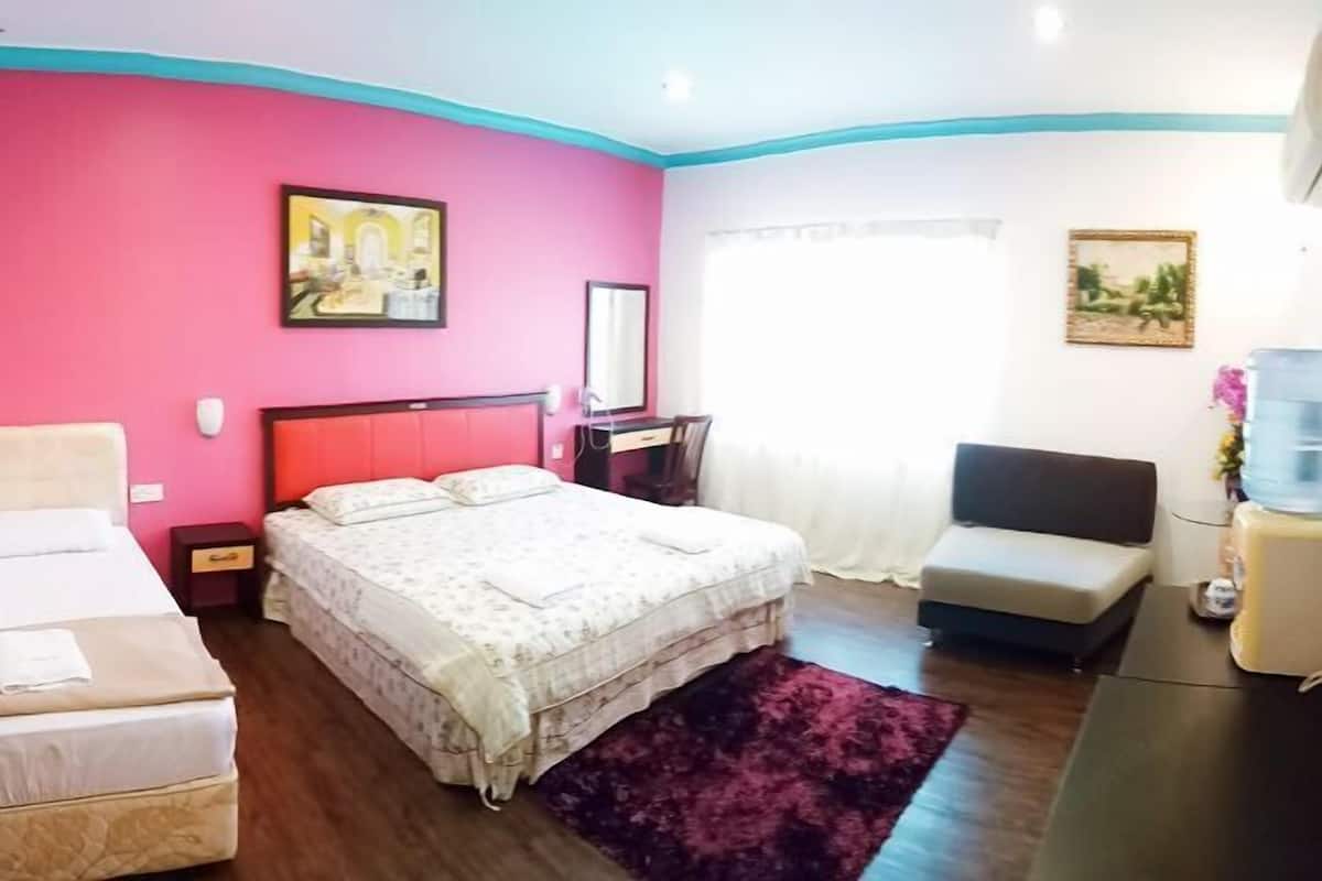 Een slaapkamer met een bed, een stoel, een bureau en een waterdispenser.