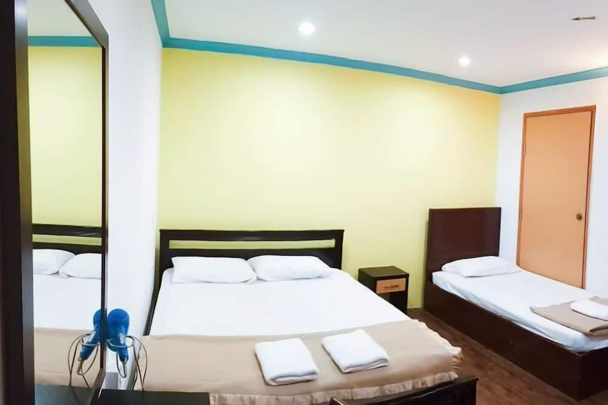 Een hotelkamer met een bed, een klein nachtkastje, een kledingkast en een nachttafel.
