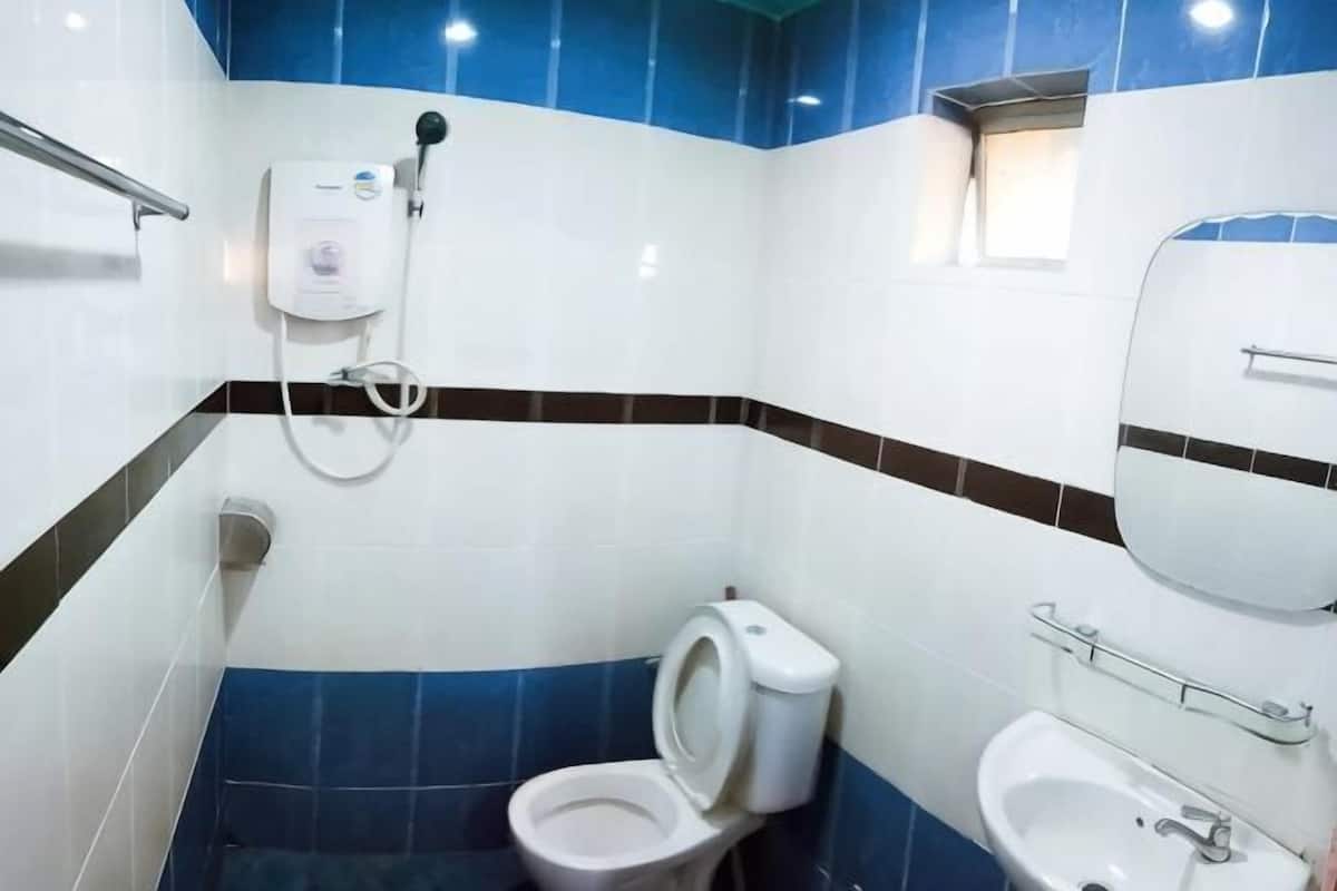 Een badkamer met toilet, bidet, wastafel en spiegel.