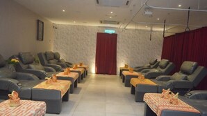 A room with massage chairs arranged in rows, each with a small table and a decorative item.