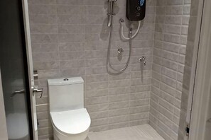 Ein Badezimmer mit Toilette, Dusche und Bedienfeld an der Wand.