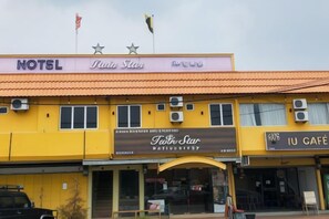 A hotel with a yellow facade, a sign for 'Teeth Star' restaurant, and a 'IU Café' on the right. - Twin Star Hotel (Tanjung Malim)