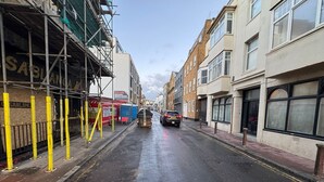 A street with buildings, scaffolding, and a parked car. - Seaside Hotel  (Brighton)
