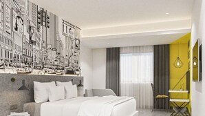 A modern bedroom with a large bed, a cityscape mural, a yellow accent wall, and a small seating area. - Yello Hotel Harbour Bay Batam (Batam)