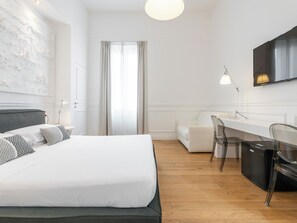 Une chambre d’hôtel moderne, dotée d’un grand lit, d’un bureau et d’une chaise.