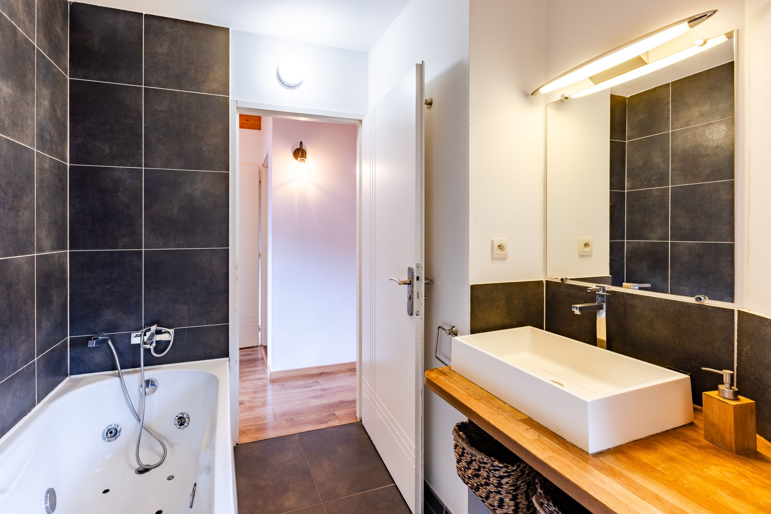 Une salle de bain moderne avec une baignoire, un lavabo et un miroir.