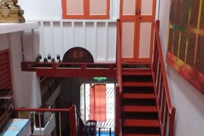 A staircase with a red handrail leading to a door marked 'Lounge'.