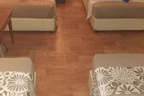 Ein Zimmer mit zwei Sofas, einem kleinen Tisch und einem gemusterten Teppich.