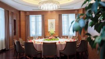 Un comedor formal con una mesa redonda, sillas y una araña.