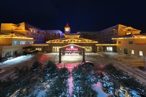 Un hôtel doté d’une entrée principale, de plusieurs étages et dont le parvis est recouvert de neige.