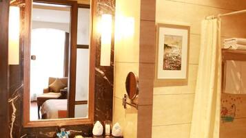 A bathroom with a marble countertop, a sink, a mirror, a framed picture on the wall, and a shower curtain.
