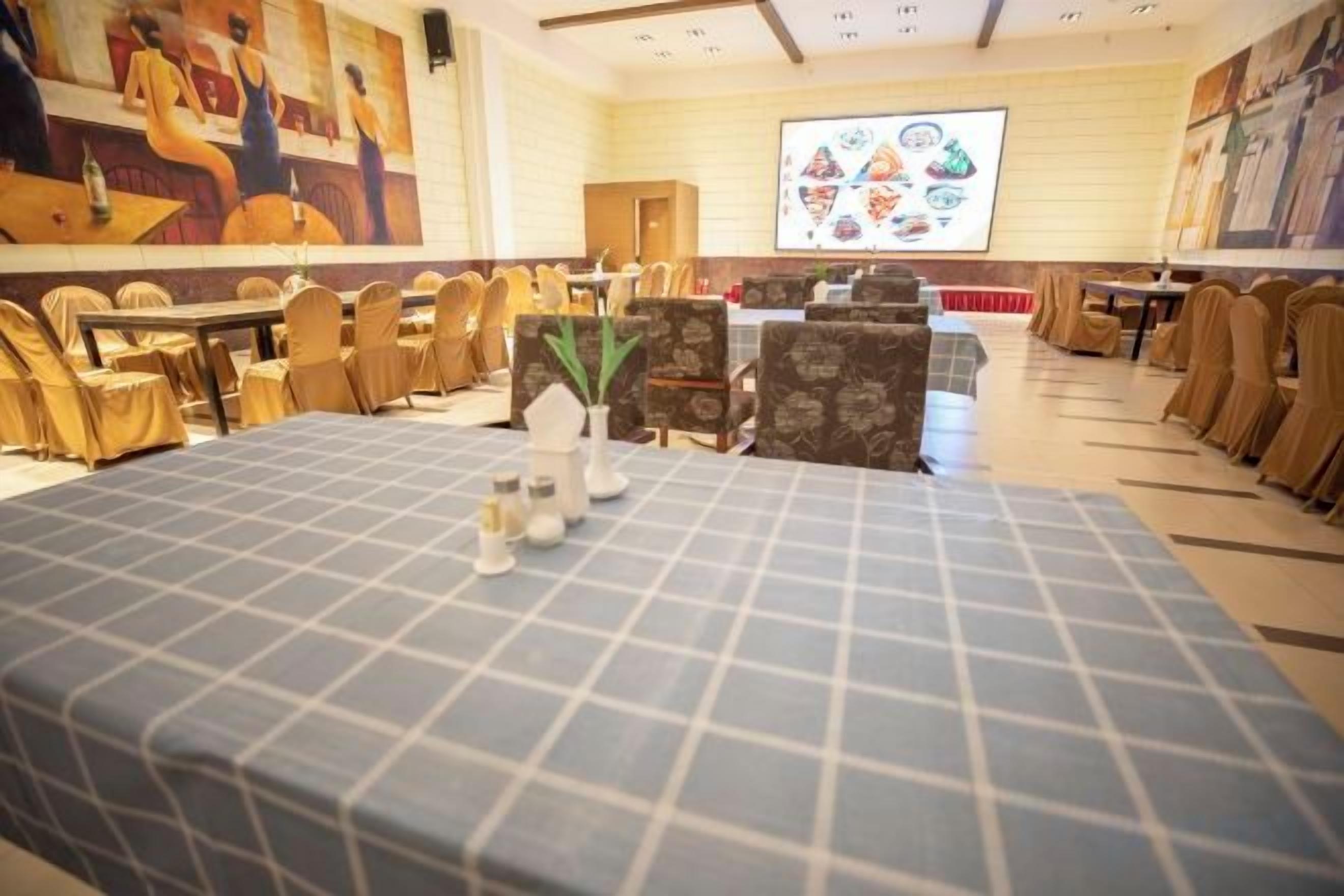 A conference room with a long table, chairs, and a projector screen.