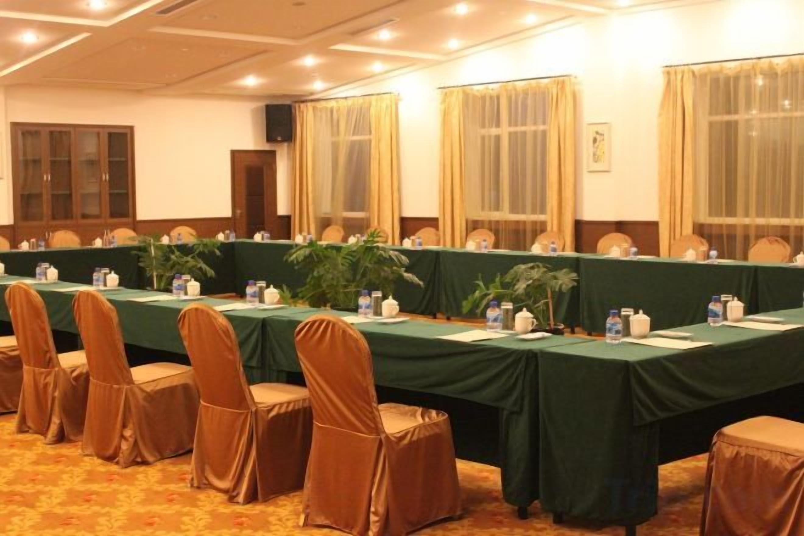 A conference room with a long table, chairs, and a carpeted floor.