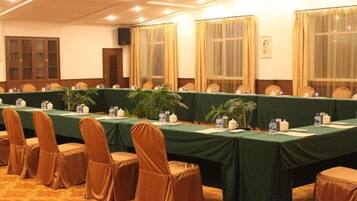 A conference room with a long table, chairs, and a carpeted floor.