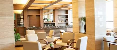 A lobby with seating, a reception desk, and a bar area.