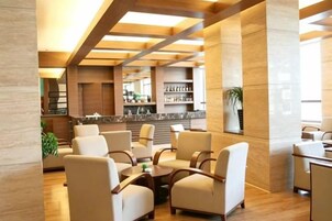A lobby with seating, a reception desk, and a bar area.
