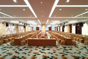 A conference room with a long table, multiple chairs, and a carpet with a leaf pattern. - Mohe Peak Yuezhiyue Hotel (Mohe)