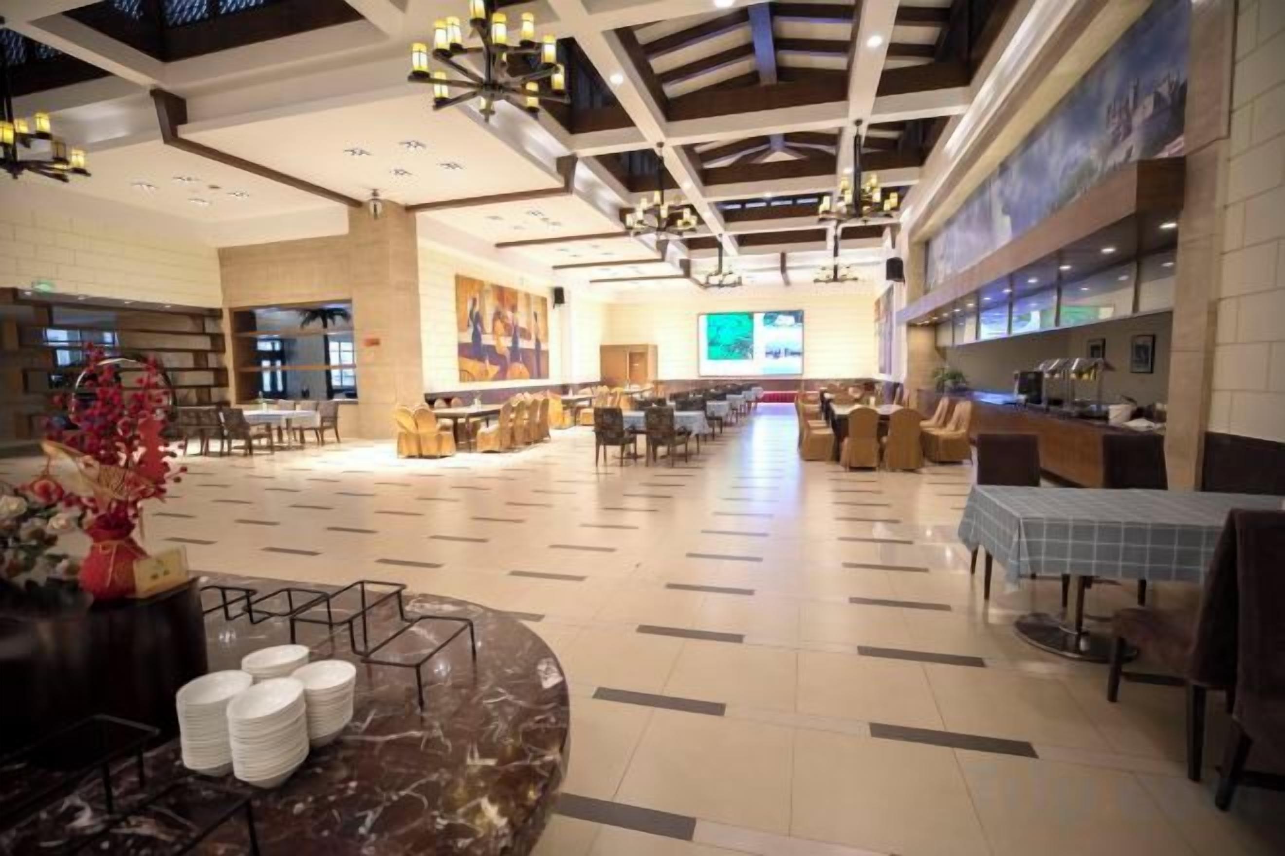 A spacious lobby with a high ceiling, a central seating area, and a reception desk.