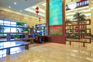 A spacious lobby with a reception desk, seating area, and decorative plants. - Mohe Peak Yuezhiyue Hotel (Mohe)