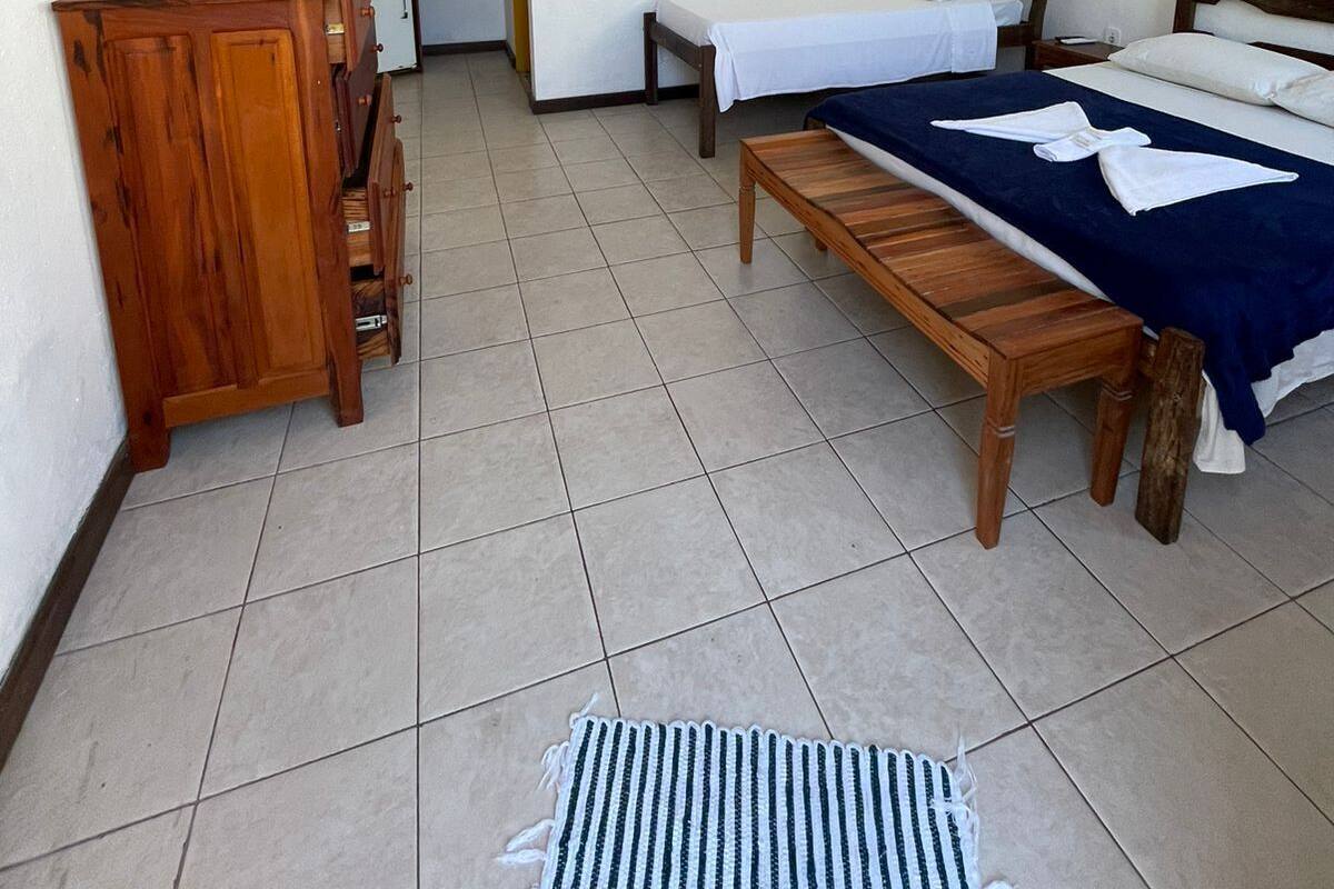 Ein Schlafzimmer mit einem Bett, einer Holzbank, einem Schreibtisch und einem kleinen Tisch.