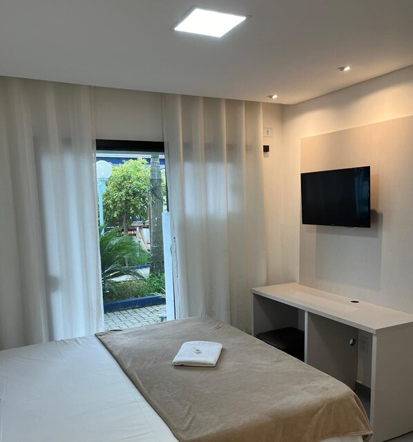 Chambre Double Deluxe | Coin séjour | Télévision, livres