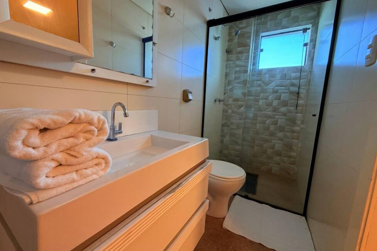 A bathroom with a white sink, a mirror, and a glass shower enclosure.