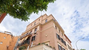 A multi-story building with balconies, air conditioning units, and a street lamp. - Belli San Giovanni Guest House (Rome)
