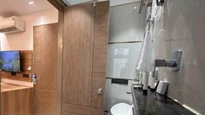 Ein modernes Badezimmer mit einem Holzbadschrank, einer Toilette und einem Waschbecken.