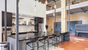 Una cocina moderna con una isla central, taburetes de bar y un comedor.