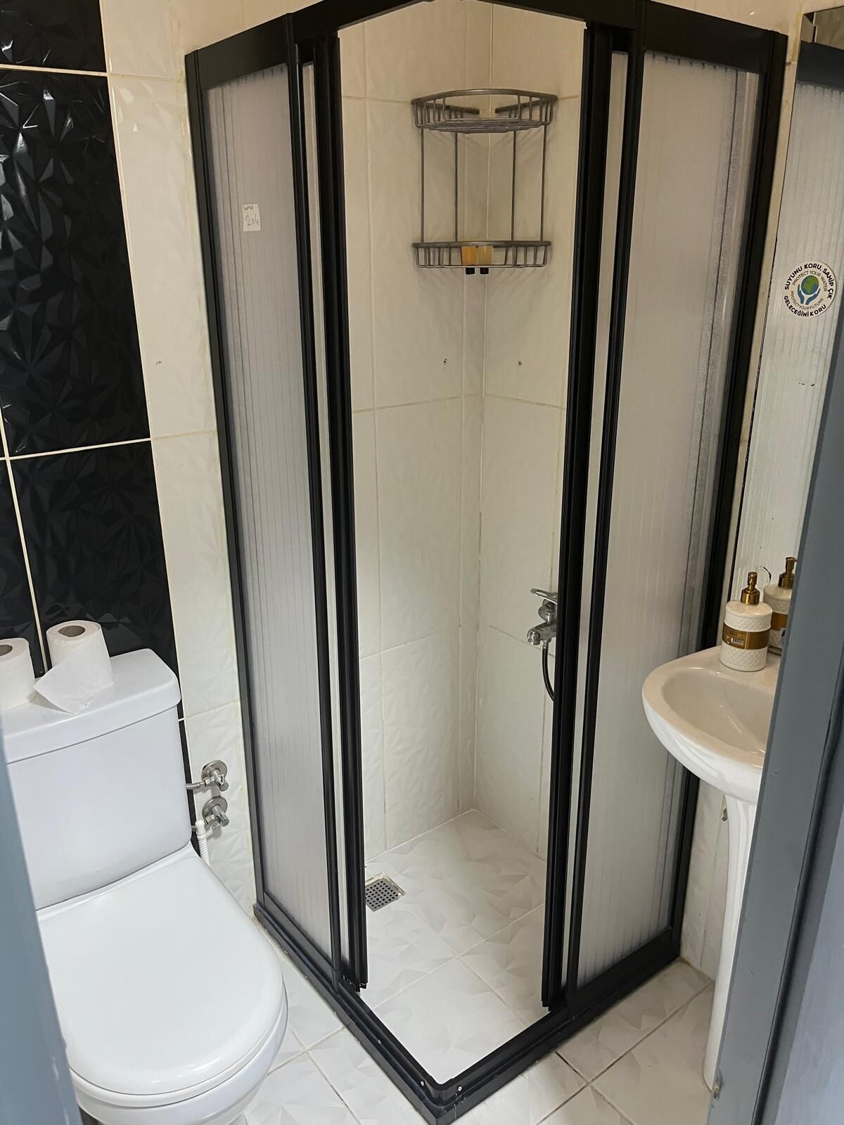 Ein Badezimmer mit Toilette, Duschkabine und Waschbecken.