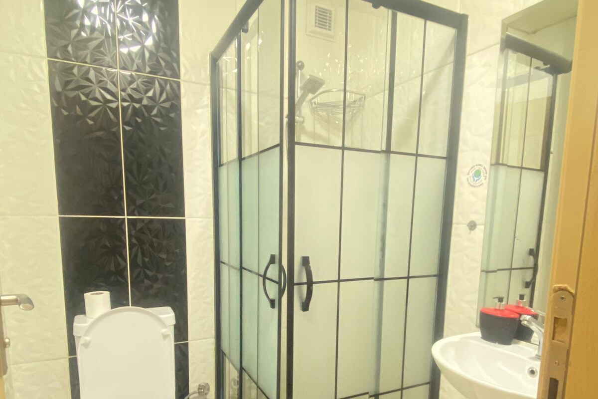 Ein Badezimmer mit Toilette, einer Duschkabine und einem Waschbecken.