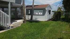 A two-story house with a covered porch and a small attached structure. - 2BR at Sandpiper Cove – Pool, Bay, Beachwalk (Englewood)