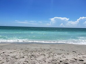 Ein Strand mit klarem türkisblauem Wasser und einem Sandufer.