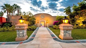 A hotel entrance with a pathway leading to a door, flanked by two stone pillars with lanterns. - 4BD Residence in San José del Cabo (San José del Cabo)