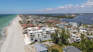 A coastal town with beachfront properties, a marina, and a clear view of the ocean.