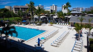 Ein Hotelpoolbereich mit mehreren Liegestühlen und einem großen Schwimmbecken.