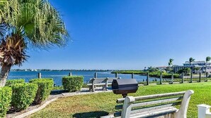 A park with a bench, a grill, and a view of the water. - Effortless Escape – Walk-Out 2BR at Tamarind (Englewood)