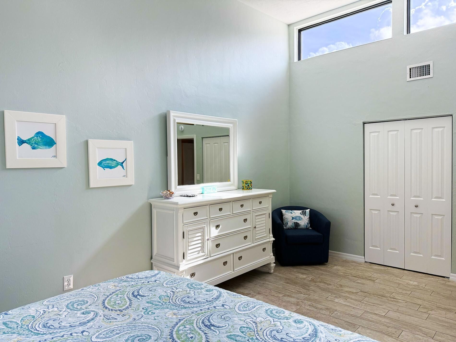 Une chambre à coucher avec un lit, une commode, une chaise et un placard.