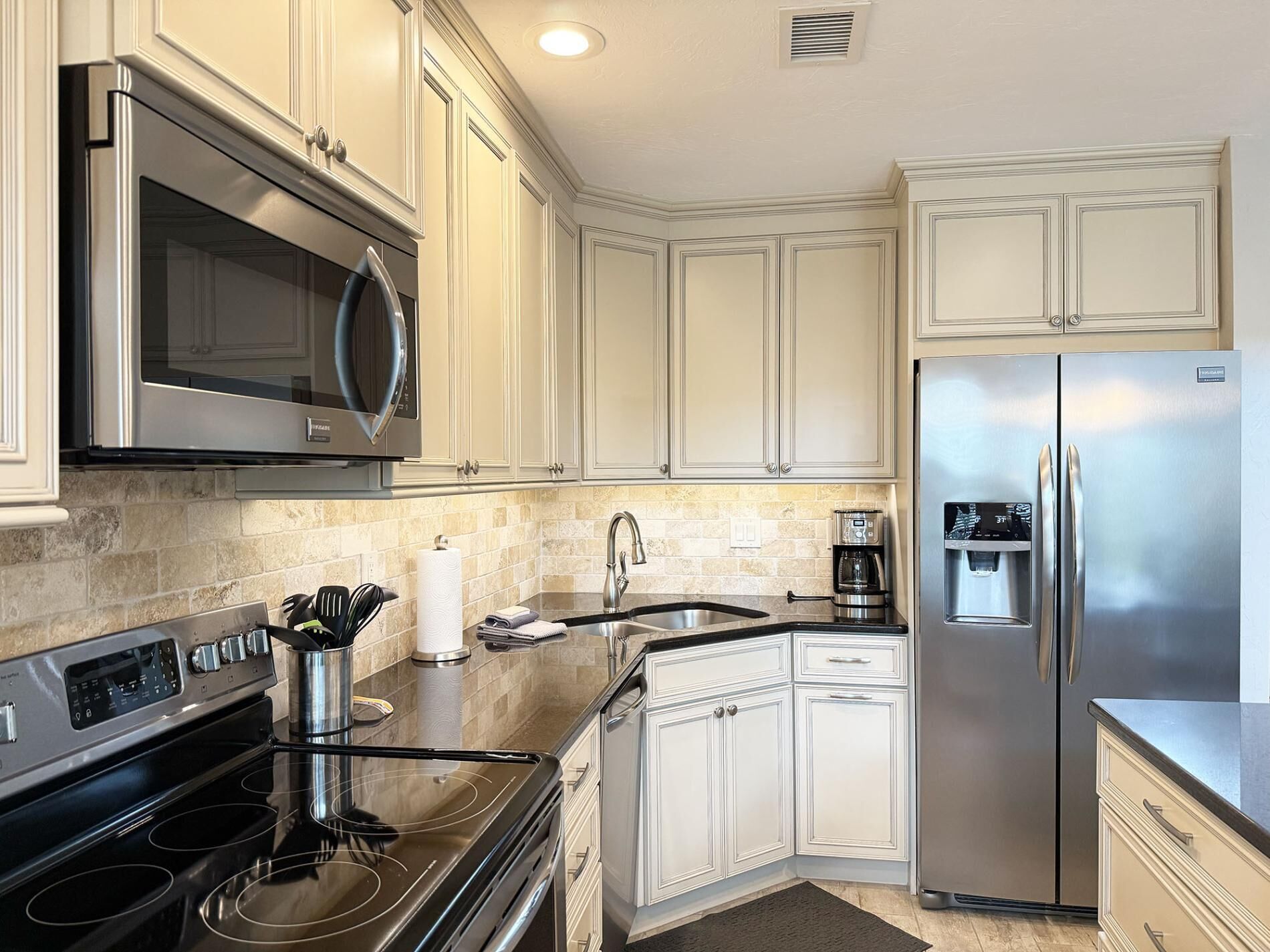 A modern kitchen with stainless steel appliances, a built-in oven, and a coffee maker.